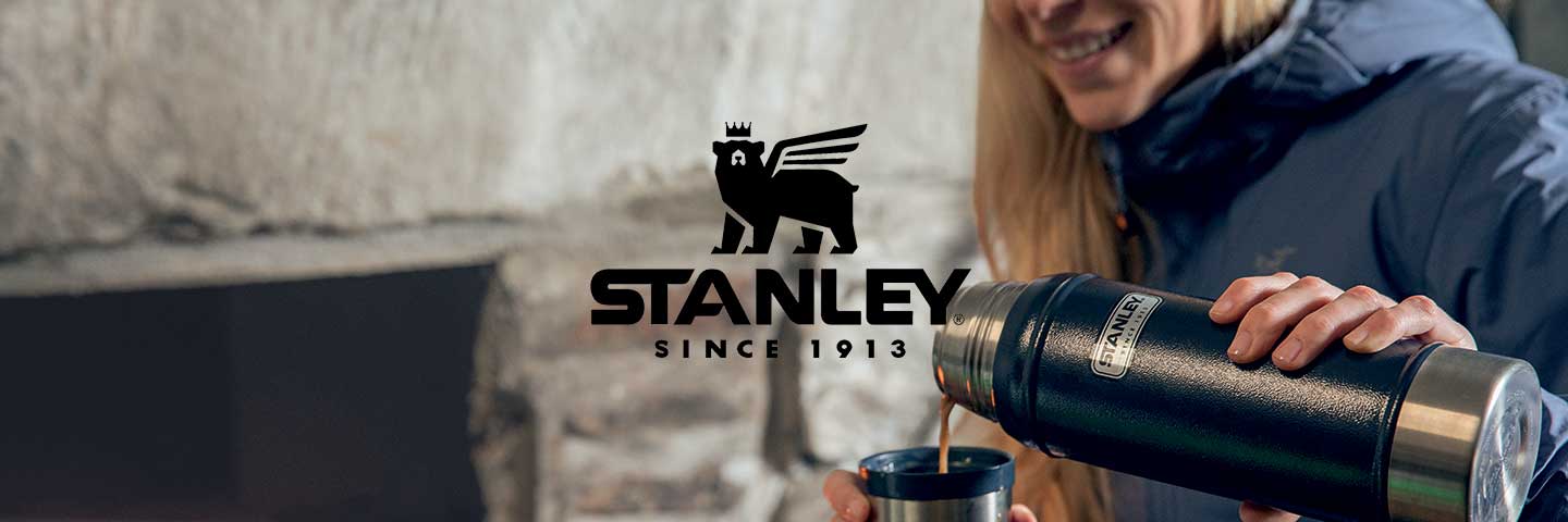 Stanley logo with woman pouring hot tea from a stanley flask in background