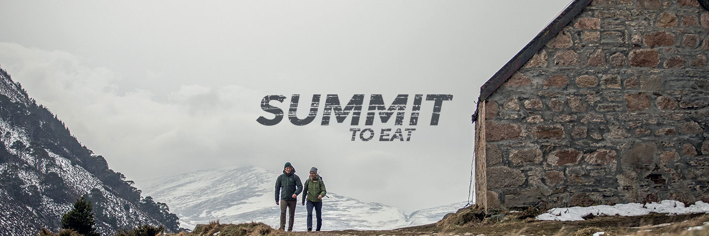 Summit To Eat logo with foggy scene with mountain hut and two walkers in background