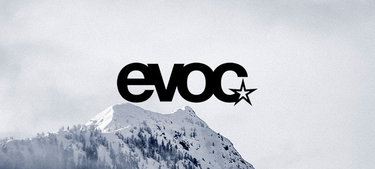 Evoc logo with snowy mountain in background
