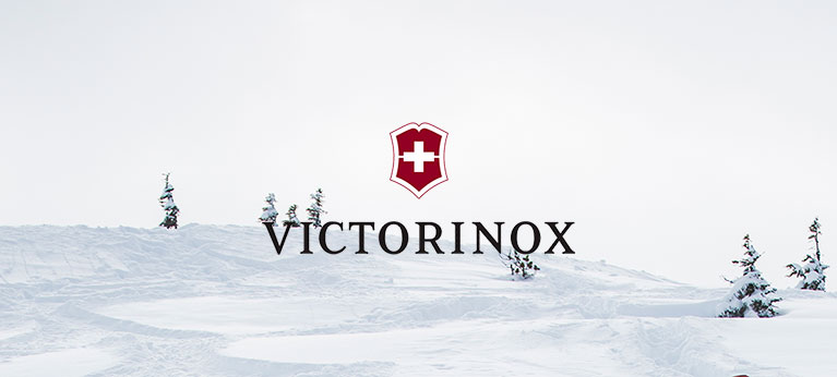 Victorinox logo with snowy ground and trees in background