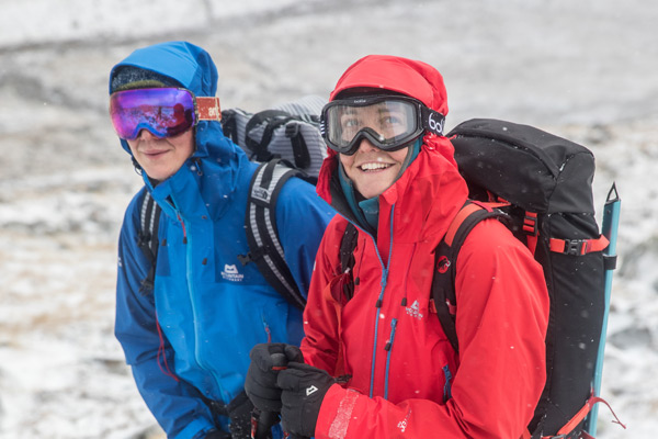 man and woman dressed in waterproof and ski goggles on mountainside
