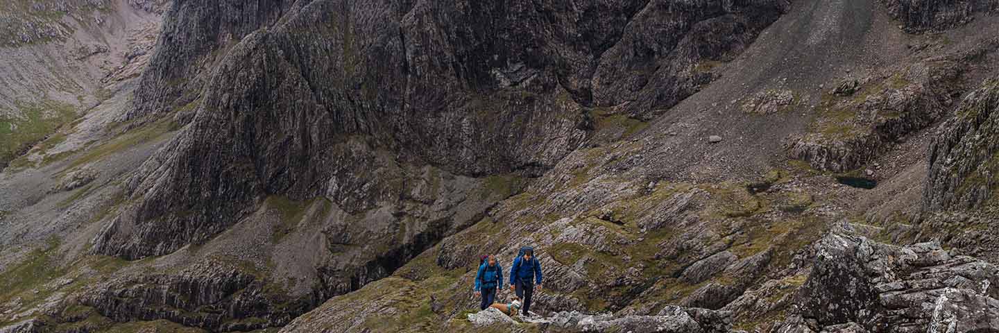 two people walking up Ben Nevis with a dog