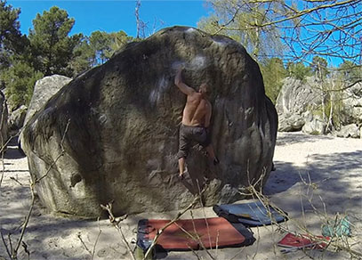 A man bouldering in the sun