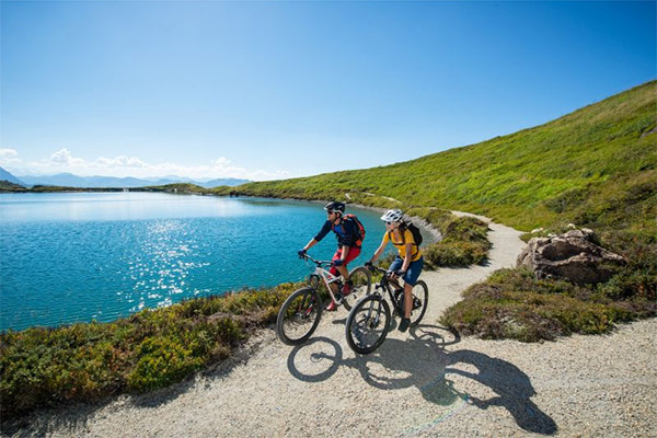 Two people cycling around a lake