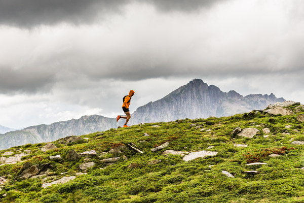 A fell runner running along a ridge