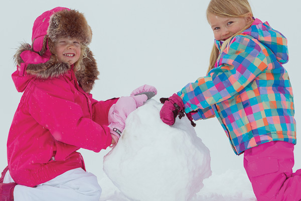 two girls building a snowman