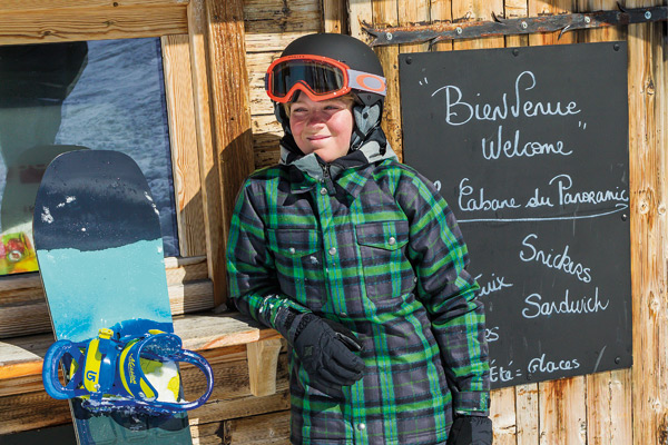 boy standing outside cafe with snowsports kit