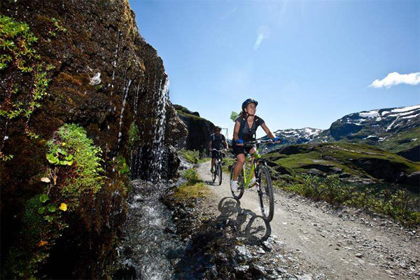 A woman and man cycling in the mountains