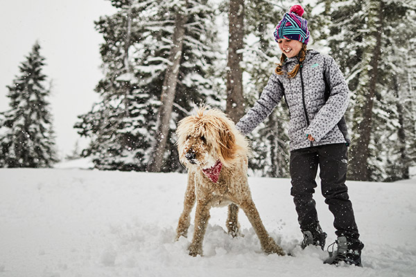 Girl in snow with dog wearing Thermoball Hoodie