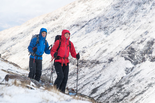 man and woman walking on wintery terrain
